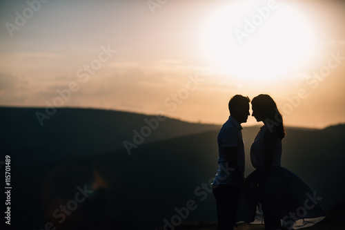 silhouette guy and girl in the mountains
