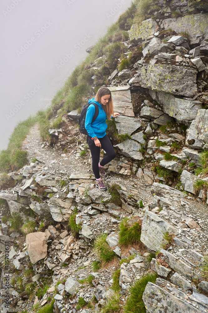 Woman backpacker hiking on a trail Woman backpacker hiking on a trail