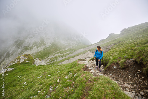 Fototapeta Naklejka Na Ścianę i Meble -  Woman backpacker hiking on a trail