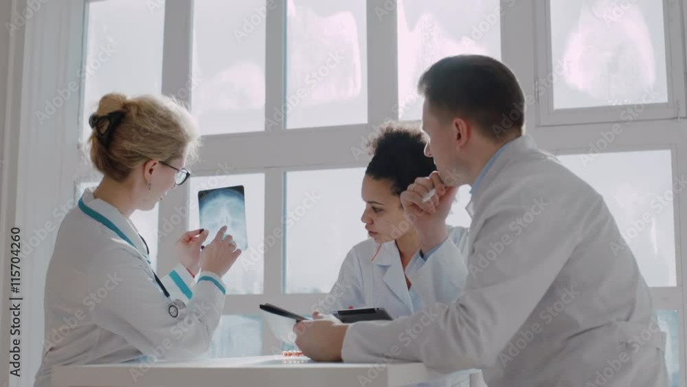 Healthcare, medical: Group of multi-ethnic doctors discuss and looking x-ray in a clinic or hospital. UHD 4K Healthcare, medical: Group of multi-ethnic doctors discuss and looking x-ray in a clinic or hospital. UHD 4K