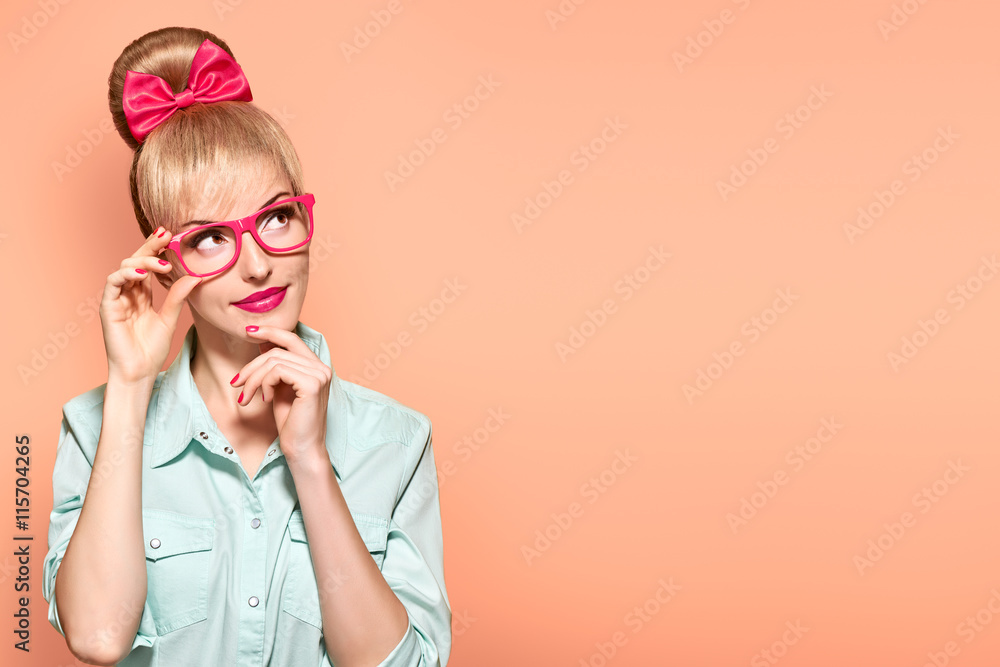Fashion. Woman in Stylish Glasses Having Fun. Hipster fashion girl think, idea. Playful nerd Blonde with Glamour Pinup Stylish hairstyle, Trendy fashion, red bow Makeup. Unusual Creative, on yellow Fashion. Woman in Stylish Glasses Having Fun. Hipster fashion girl think, idea. Playful nerd Blonde with Glamour Pinup Stylish hairstyle, Trendy fashion, red bow Makeup. Unusual Creative, on yellow