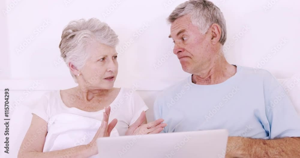 Senior couple in bed talking Senior couple in bed talking