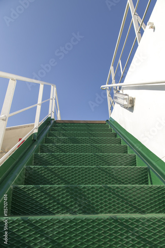 Stairway to heaven, green metal stairs on a ferry boat, against beautiful  bright blue summer sky © perfectmatch
