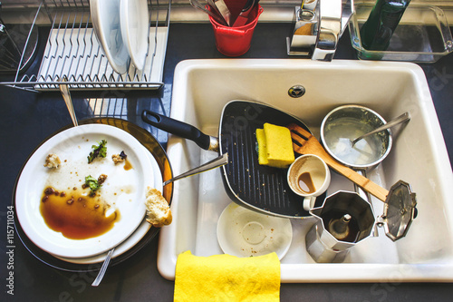 A lot of dirty dishes in the white sink in the kitchen photo