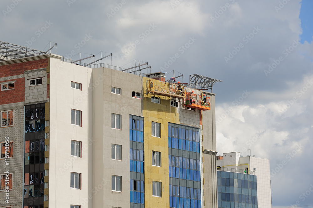 Fototapeta premium Construction workers thermally insulating house facadel.