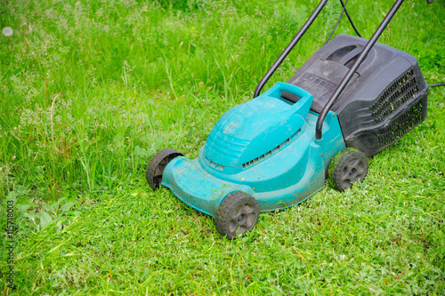 Green electric mowing-machine on the grass