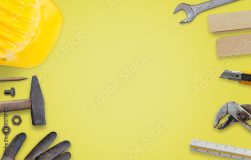 Construction tools with free space for text on yellow desk.