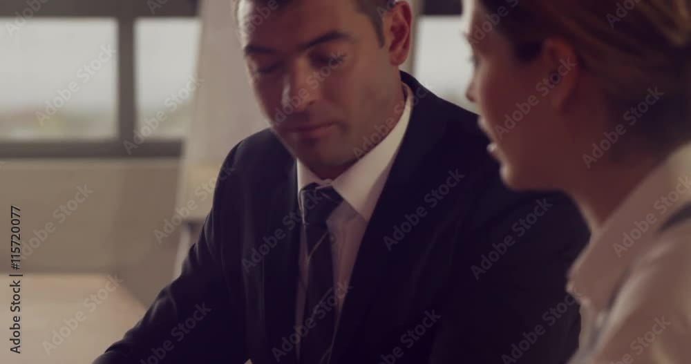 Serious business people working together while looking tablet in office Serious business people working together while looking tablet in office