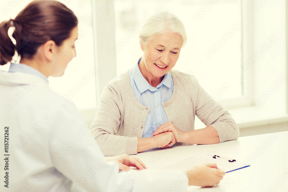 Fototapeta premium doctor with clipboard and senior woman at hospital