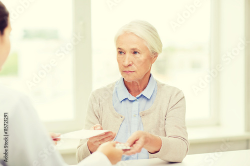 doctor giving prescription and drug to woman 