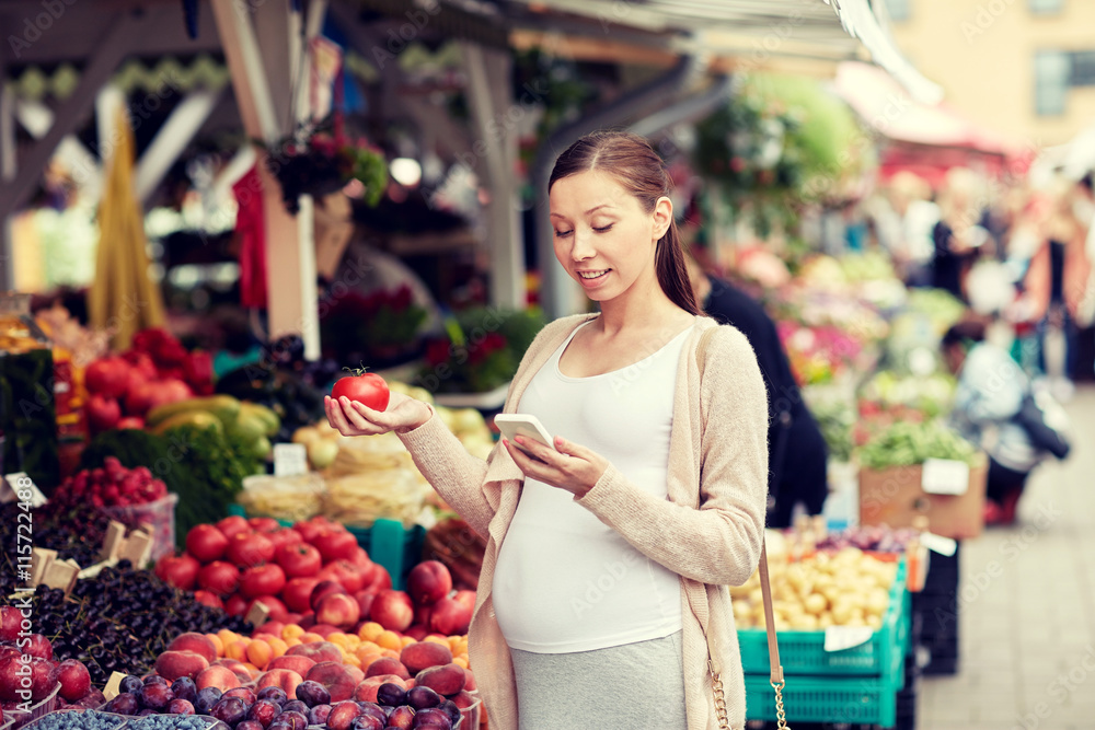 pregnant woman with smartphone at street market