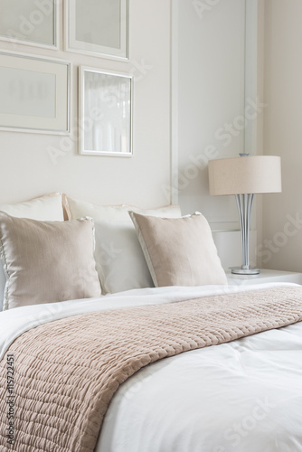 modern lamp on table side with picture frame on wall in bedroom