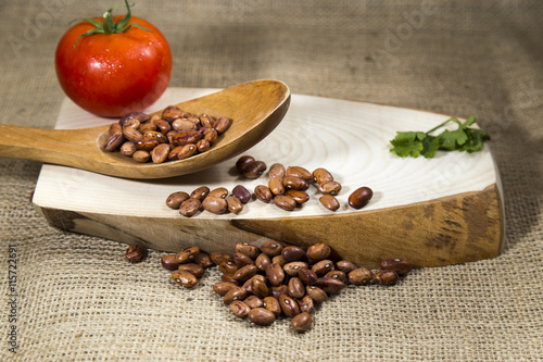 Fototapeta Naklejka Na Ścianę i Meble -  Organic red dried beans over wooden tray and sackcloth, studio image