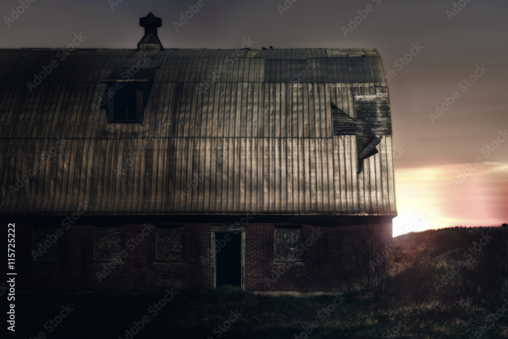 Fototapeta premium Old barn on a farm, sunrise in background.