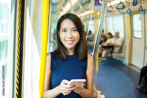 Canvas Print Woman using mobile phone in metro compartment