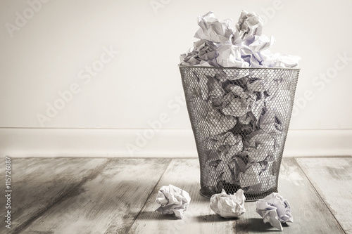 Crumpled paper in the trash can photo