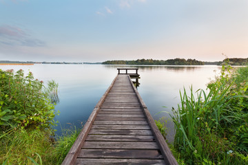 Fotobehang Pier Lange pier op kalm meer  © Olha Rohulya