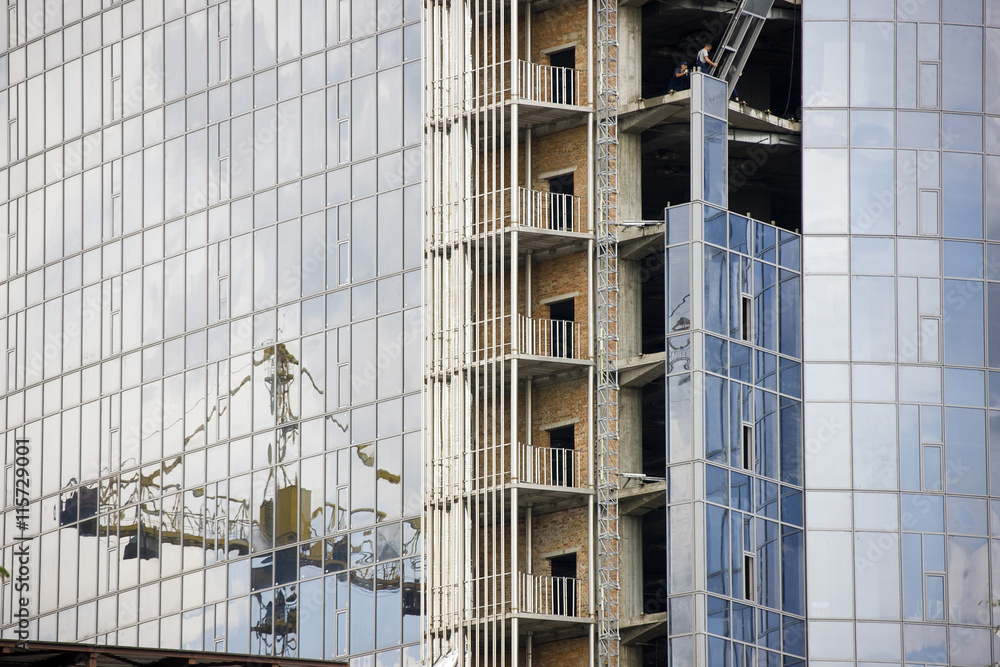 Reflection of a construction site in windows of modern office building Reflection of a construction site in windows of modern office building