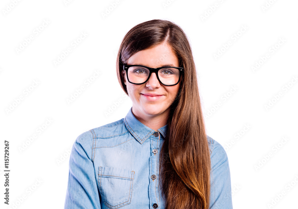 Girl in denim shirt and black eyeglasses, studio shot