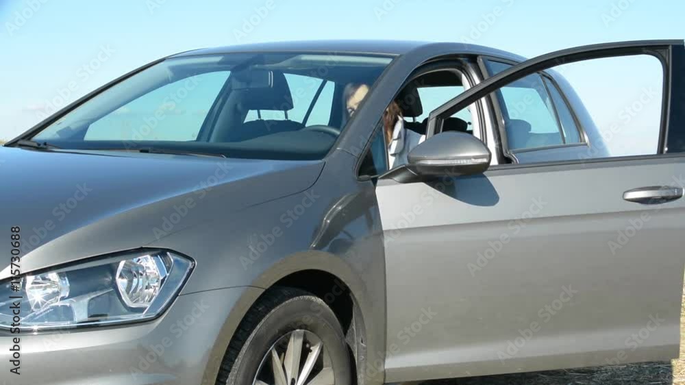 view of the car - young attractive woman gets in the new car view of the car - young attractive woman gets in the new car
