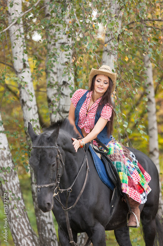 Beautiful smiling woman caress black horse © Zadiraka