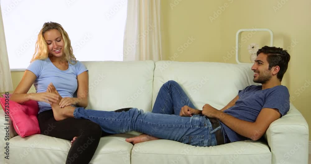 Caring girlfriend giving her boyfriend a foot rub Caring girlfriend giving her boyfriend a foot rub