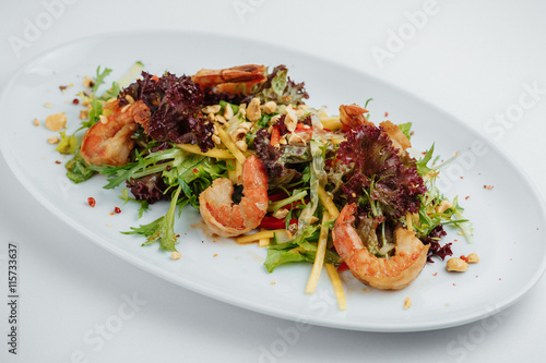 Shrimp salad and greens on a white plate