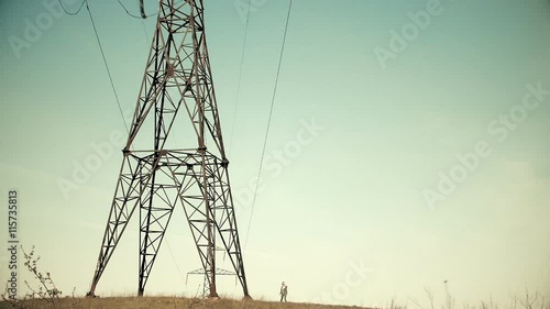 Girl walking near the lines electicity in the wasteland in Ukraine