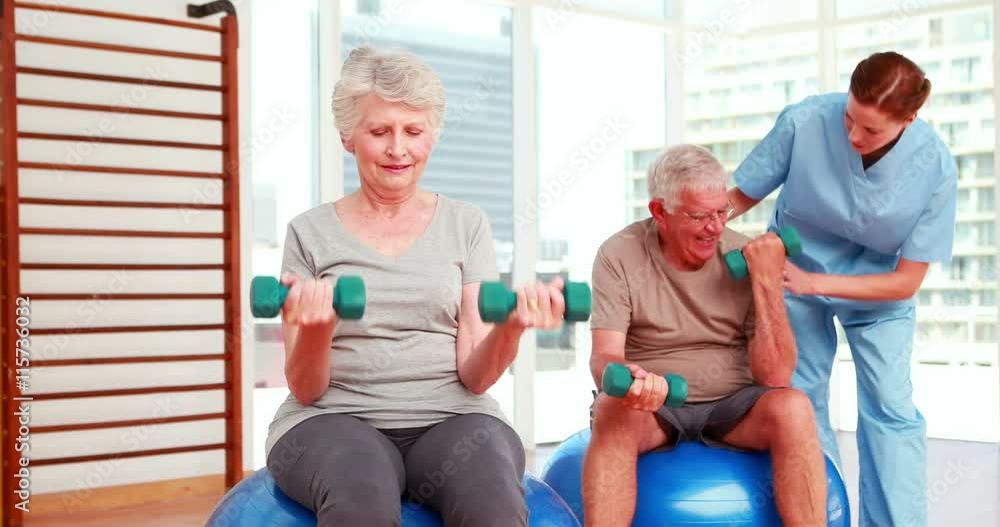 Two senior citizens exercising with physiotherapist Two senior citizens exercising with physiotherapist