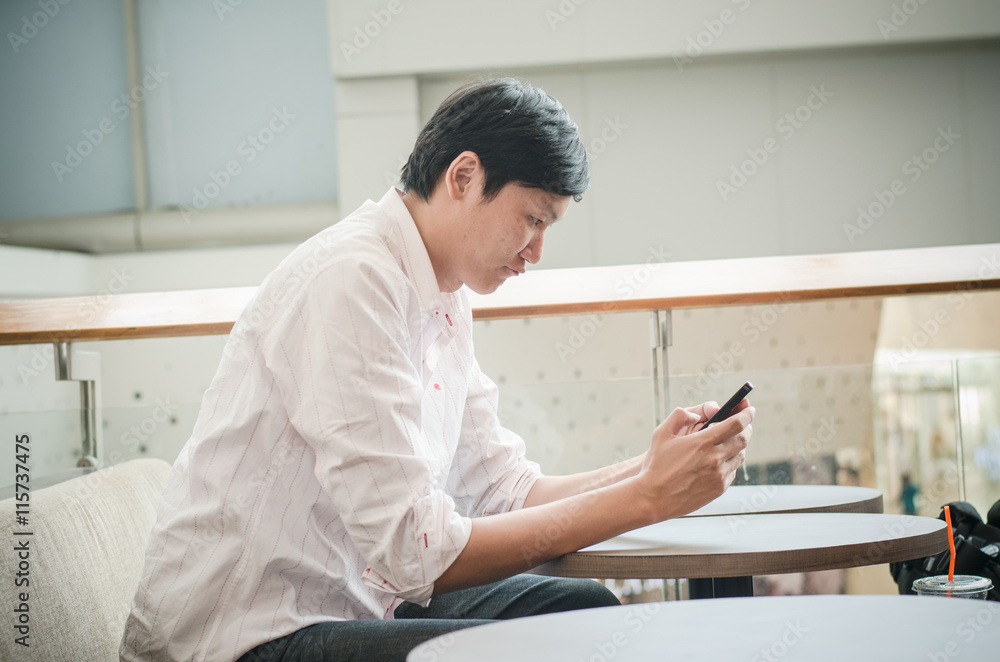 asian man. businessman looking on mobile phone in modern office asian man. businessman looking on mobile phone in modern office