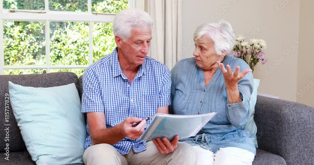 Worried senior couple looking at document Worried senior couple looking at document