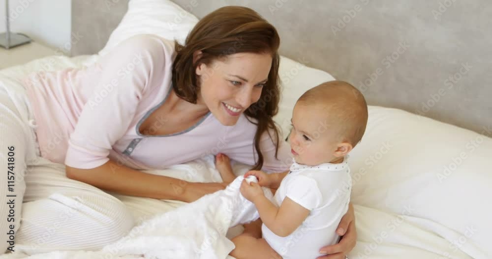 Mother playing with her baby daughter on the bed Mother playing with her baby daughter on the bed
