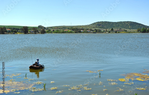 Pescador con flotador hinchable en la presa romana de Proserpina, Mérida, Badajoz, España photo
