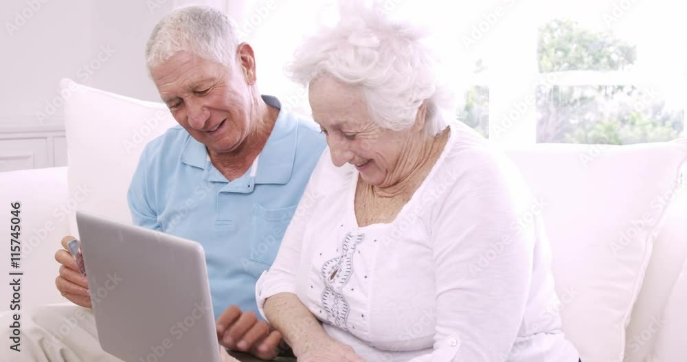 Smiling senior couple using laptop Smiling senior couple using laptop