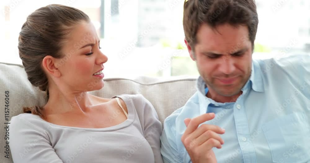 Man surprising his girlfriend with a present on the couch