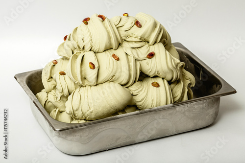 Pistachios ice cream in the metal tray on white background