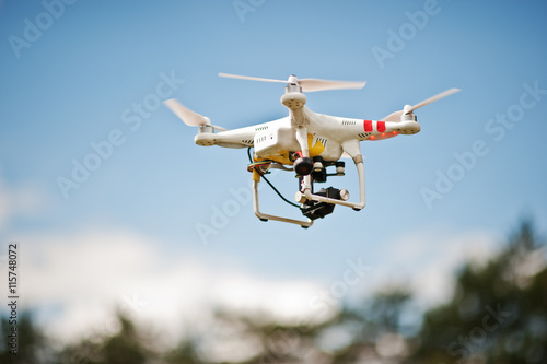 Drone quad copter with high resolution digital camera flying in
