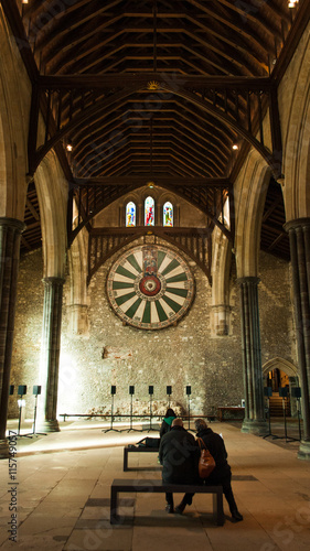 People contemplating King Arthur Round table in Winchester Great Hall, UK