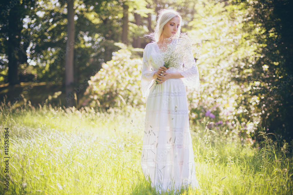 Hippie bride holding white flowers standing in forest Hippie bride holding white flowers standing in forest
