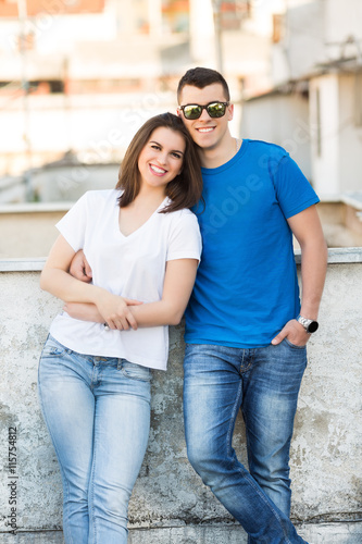 Young couple standing on a roof balcony and smiling