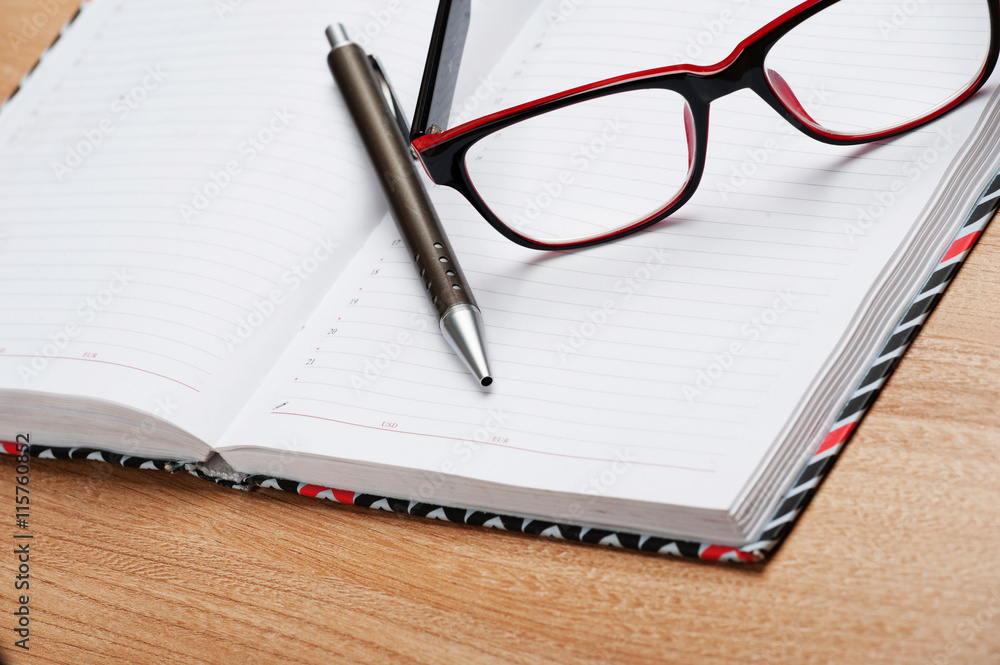 On a wooden table lie objects organizer, diary, glasses, On a wooden table lie objects organizer, diary, glasses,
