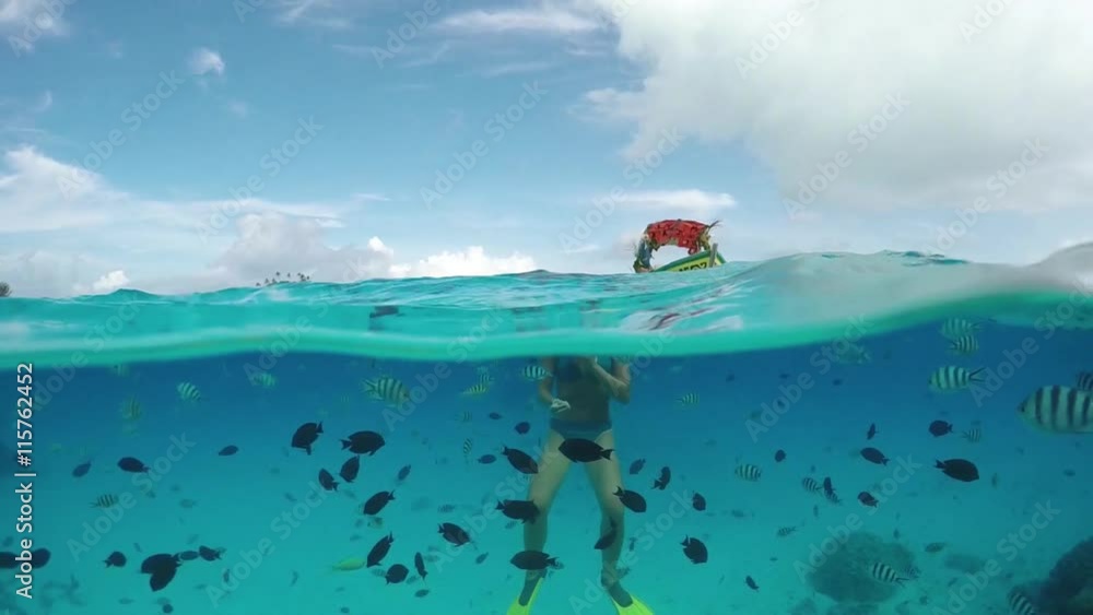 SLOW MOTION UNDERWATER: Woman snorkeling exotic reef with tropical fish SLOW MOTION UNDERWATER: Woman snorkeling exotic reef with tropical fish