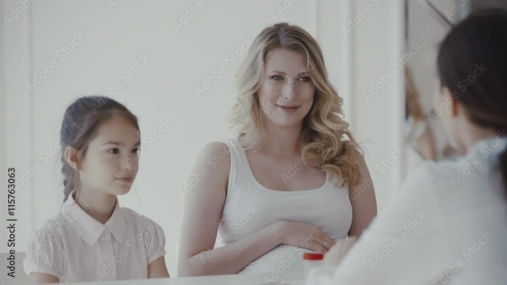 Doctor consulting family pregnant mother with daughter in a hospital. 4K Doctor consulting family pregnant mother with daughter in a hospital. 4K