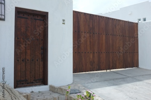 Wooden gate and door on white wall