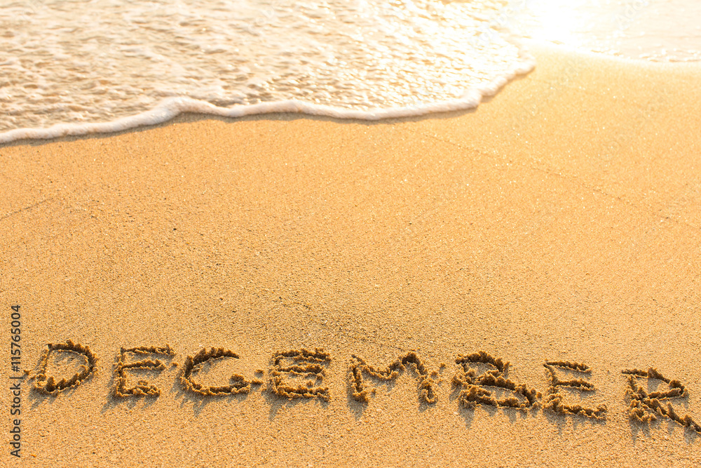Fototapeta premium December - drawn by hand on a golden sandy sea beach.