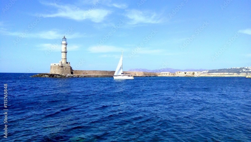 Sailing White Yacht Near The Lighthouse on The Aegean Sea, Chania, Crete Island, Greece