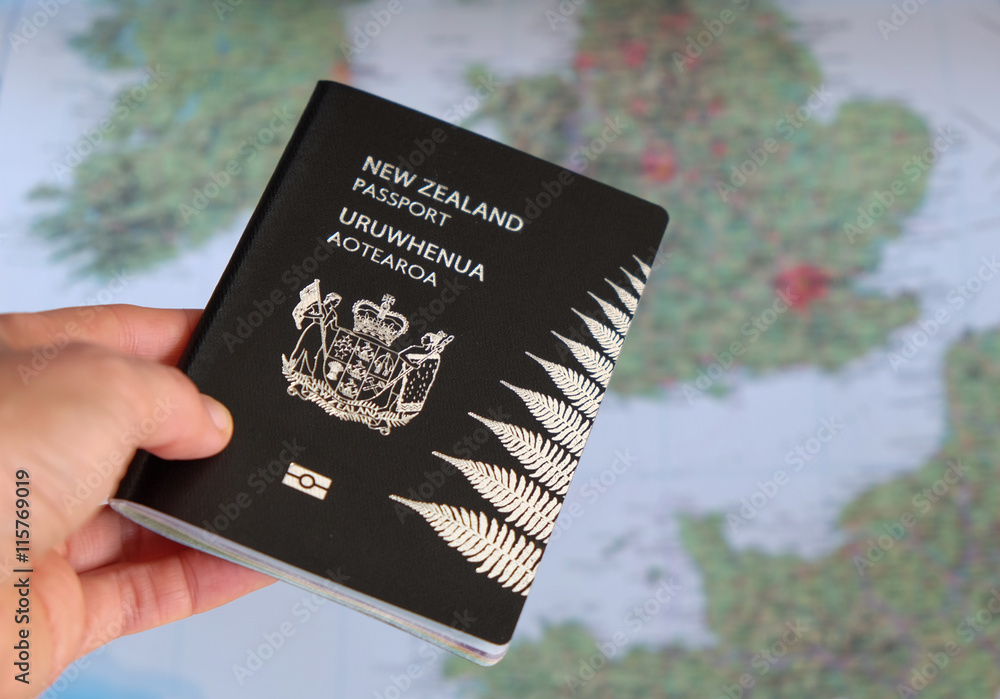 Hand Holding A New Zealand NZ Passport In Front Of A Map Of Europe australian-passport-renewal-the-requirements-cost-and-time-wise