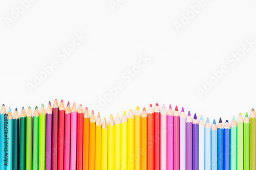 Colored pencils in rainbow order on white background. Pencils background.