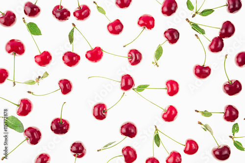 Scattered fresh ripe cherries with tails, leaves on a white background. Cherry background. Fruit background.
