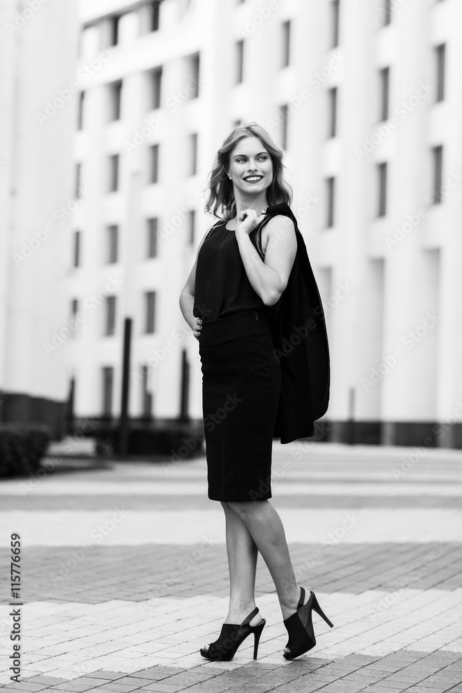 Black-and white portrait of business woman outside office buildings